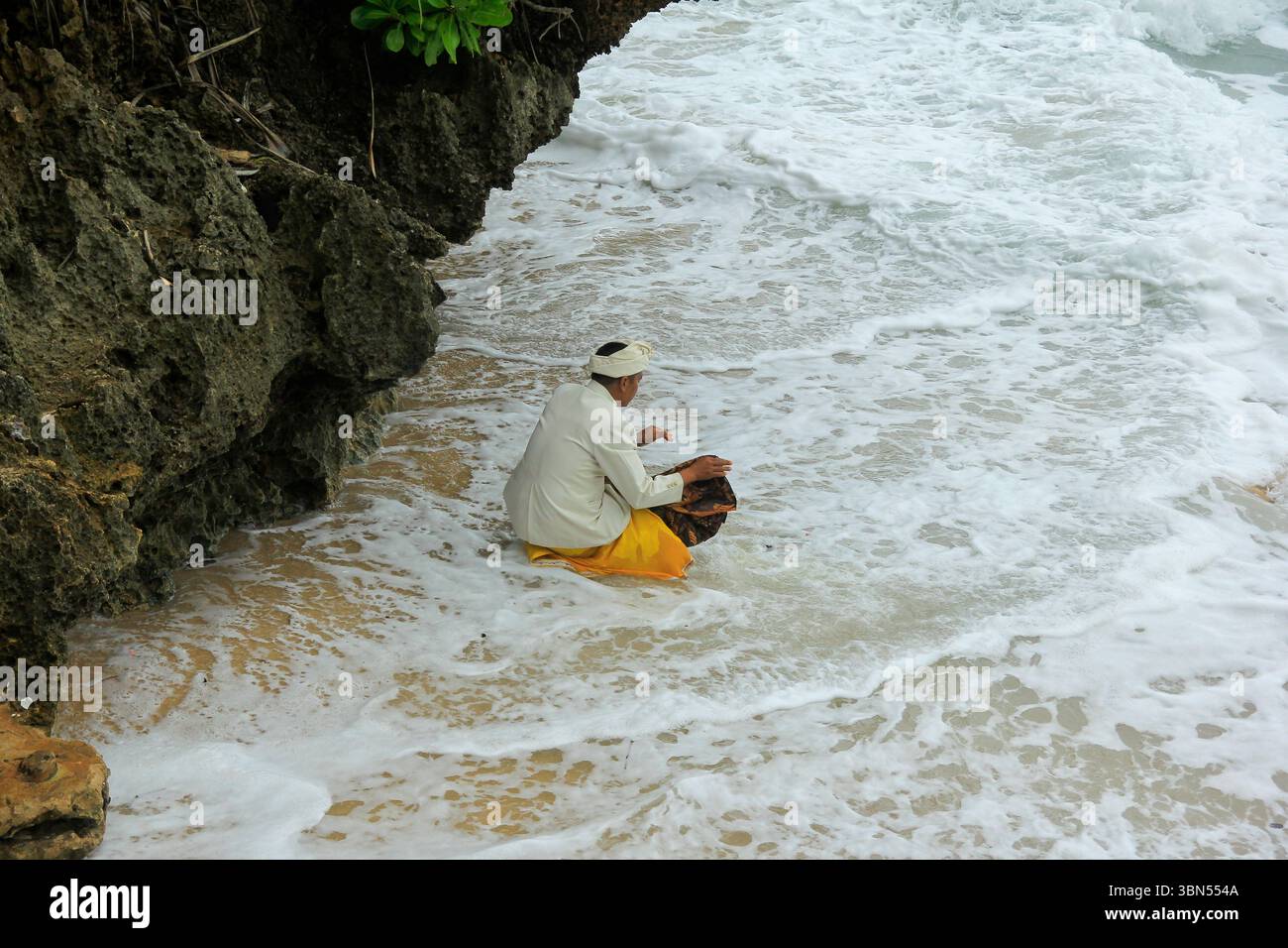Gli indù pregano durante la cerimonia Melasti a Ngobaran Beach. La cerimonia è un giorno di silenzio, volto a purificare il corpo e l'anima dall'elemento negativo. Foto Stock