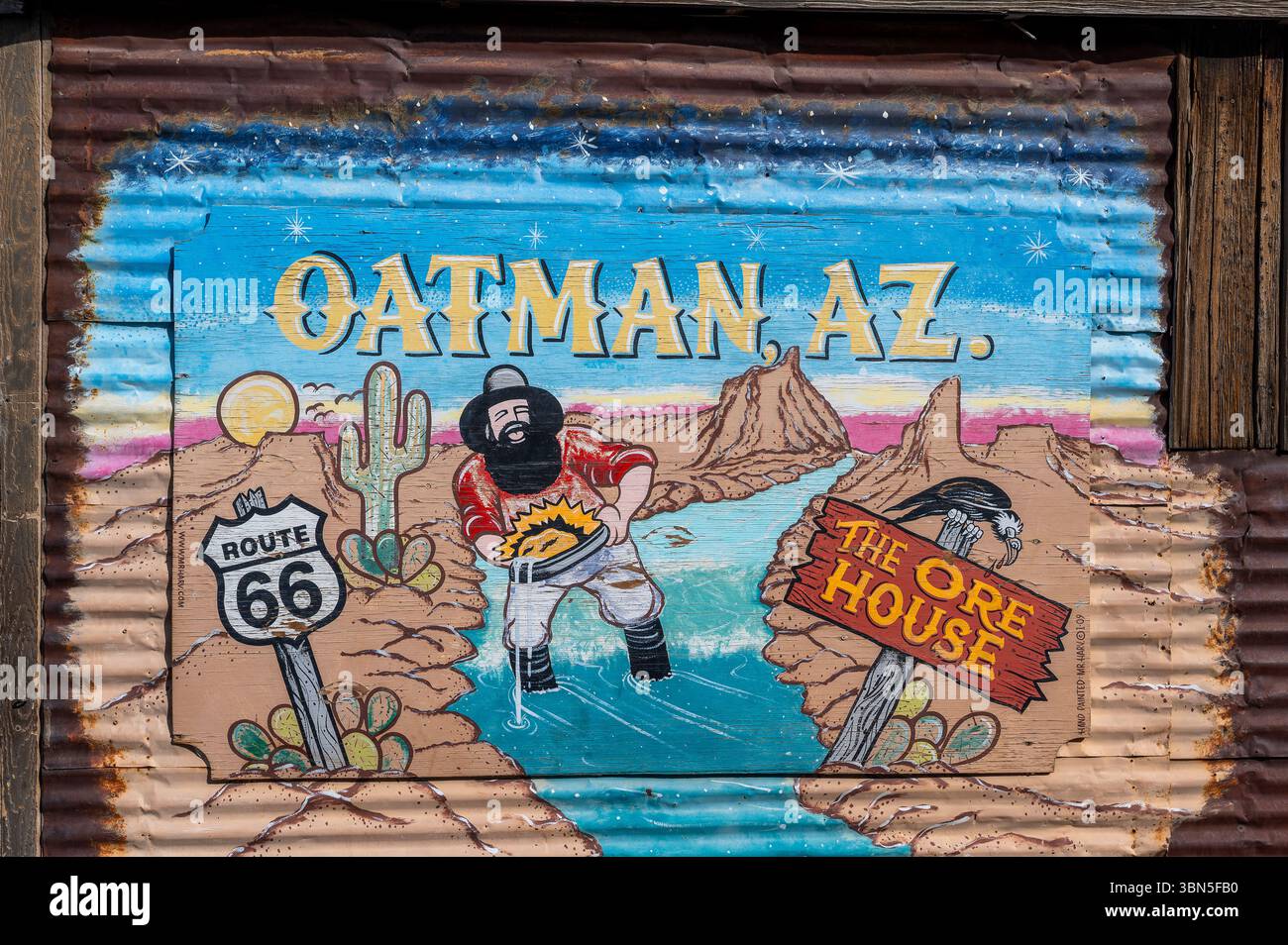 Murale colorato a Oatman, Arizona, che raffigura un cercatore d'oro con barba che si snoda in un paesaggio desertico con la Route 66 e i cartelli della casa delle ore, che evocano Ol Foto Stock