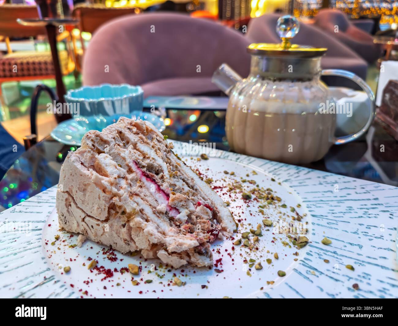 Primo piano di una squisita torta multistrato con pistacchio e panna, un dolce perfetto in un elegante ristorante. Foto Stock