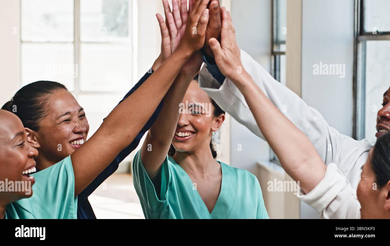 Diverse Medical Team impegnata in un United High-Five celebrando il successo Foto Stock