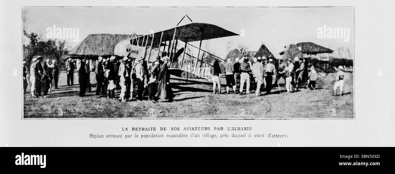Biplano militare francese circondato dagli uomini di un vicino villaggio albanese, poco dopo l'atterraggio durante una ritirata attraverso l'Albania durante la prima guerra mondiale immagine pubblicata su l'Illustration, 22 gennaio 1916. La scena cattura la ritirata degli aviatori alleati attraverso i Balcani dopo il crollo della Serbia, evidenziando l'interazione tra gli abitanti del villaggio e gli equipaggi dell'aviazione in tempo di guerra. Foto Stock