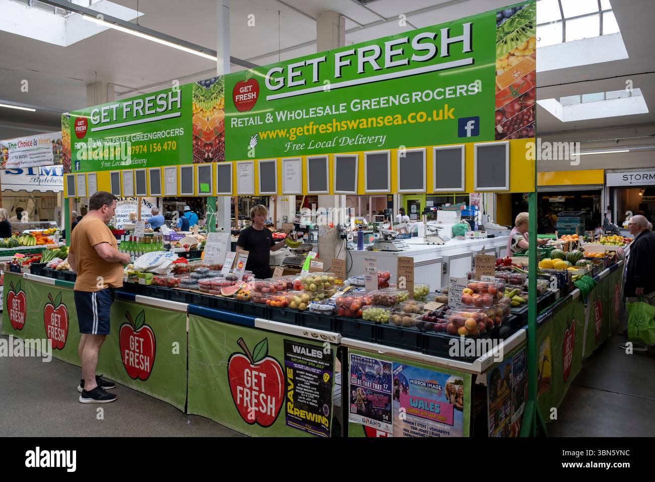 Chiosco di frutta e verdura nel mercato interno di Swansea nel centro della città il 27 giugno 2025 a Swansea, Galles, Regno Unito. Swansea Market è il più grande mercato coperto del Galles e ha vinto il premio Britains Best Large Indoor Market nel 2024. Il centro della città, pur rimanendo un centro commerciale per Swansea, ha un basso livello di occupazione rispetto ad altre città, con il risultato di spendere meno denaro e aggravare il lento declino dello shopping nelle strade principali e la prosperità economica nell'area. Foto Stock