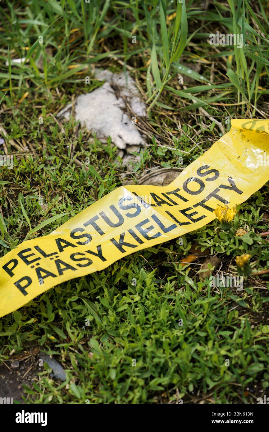 Nastro giallo su erba con testo in finlandese: Pelastuslaitos Pääsy Kielletty (servizi di emergenza - nessun ingresso). Foto Stock