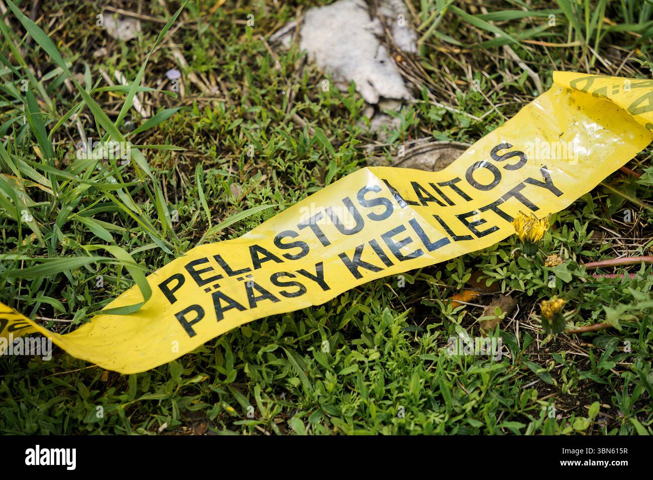 Nastro giallo su erba con testo in finlandese: Pelastuslaitos Pääsy Kielletty (servizi di emergenza - nessun ingresso). Foto Stock