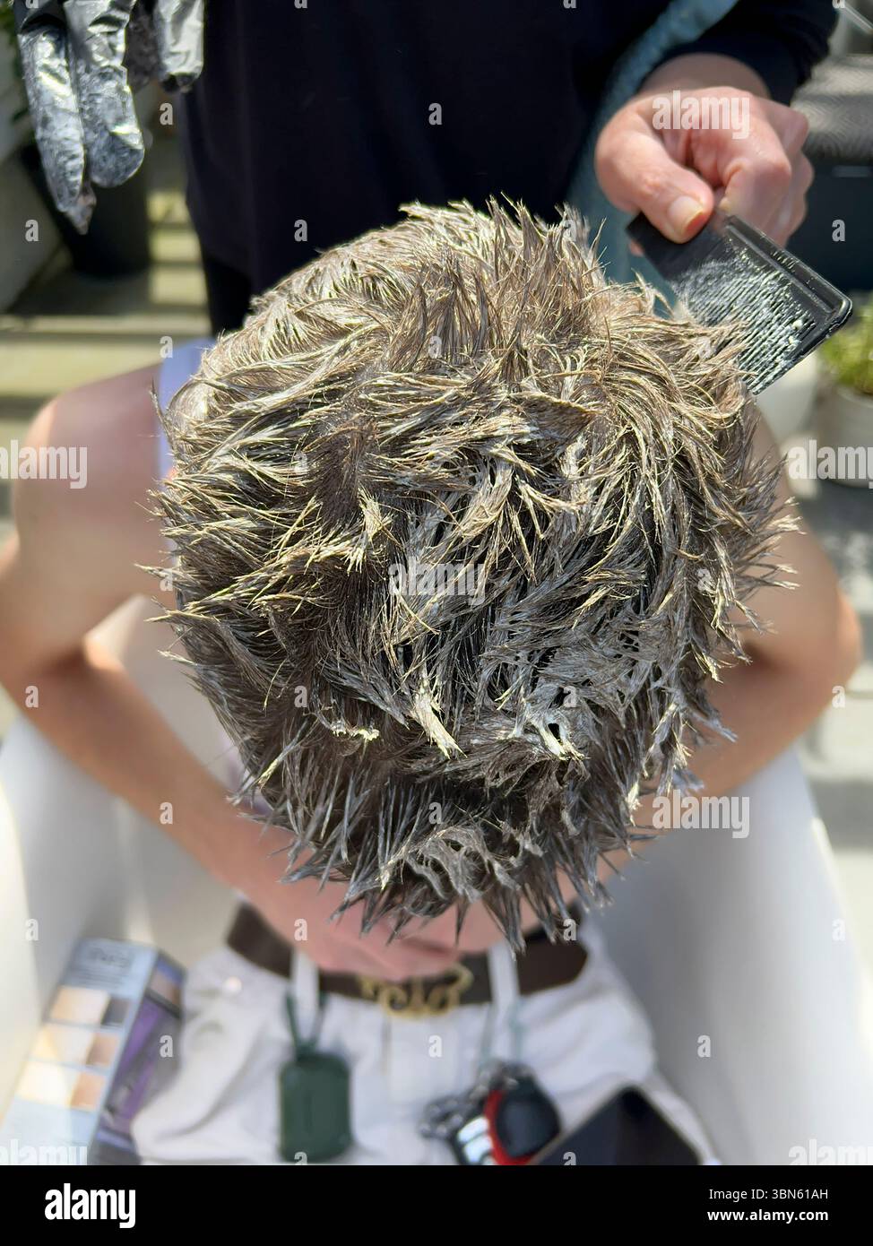 Vista ad angolo alto del giovane uomo adulto che si sbiancano i capelli Foto Stock
