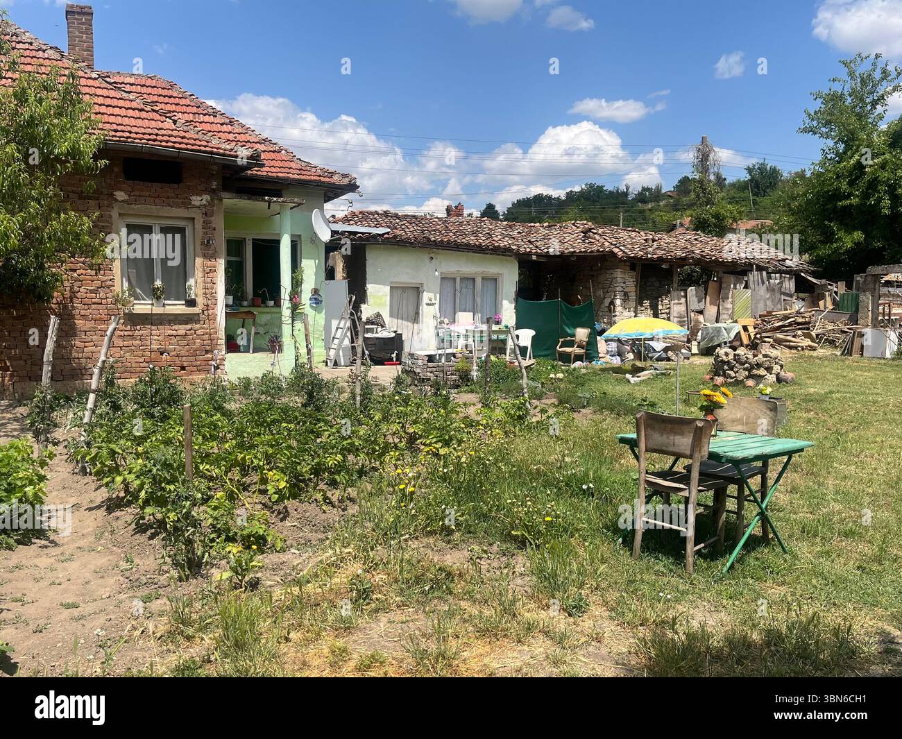 Semplice cortile di una tradizionale casa di villaggio nella Bulgaria rurale, Europa orientale, che mostra l'autentica vita di campagna balcanica e il fascino rustico Foto Stock