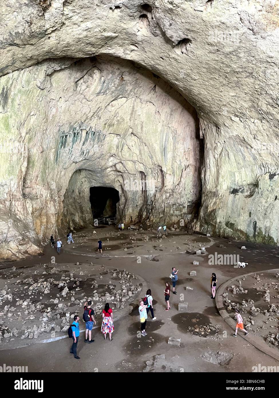 I turisti ammirano l'enorme interno a cupola della Grotta di Devetashka, una meraviglia naturale in Bulgaria, Europa orientale, penisola balcanica Foto Stock