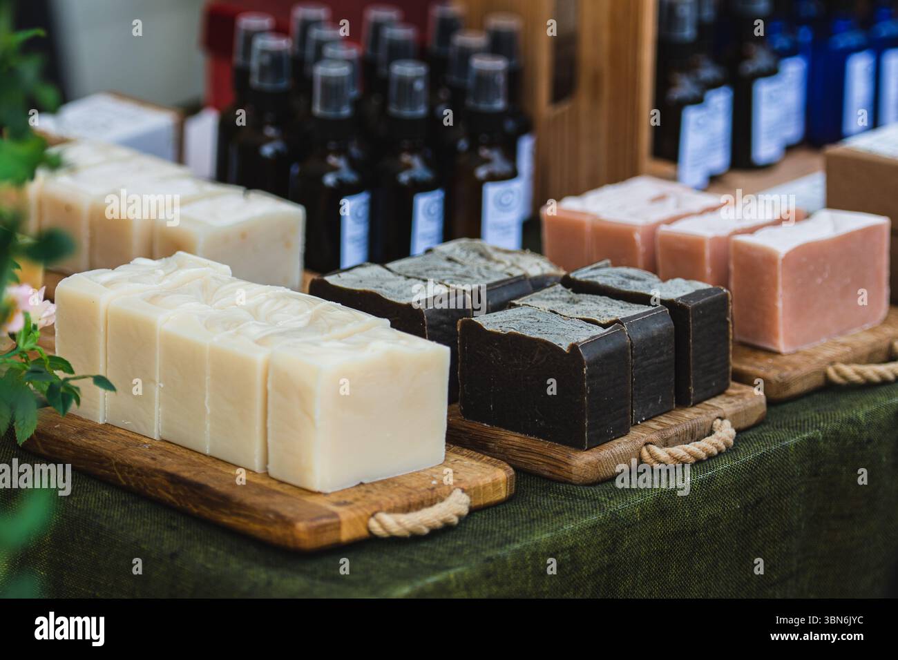 Barrette di sapone biologiche fatte a mano su tavole di legno per la vendita in una fiera o mercato di artigianato popolare Foto Stock
