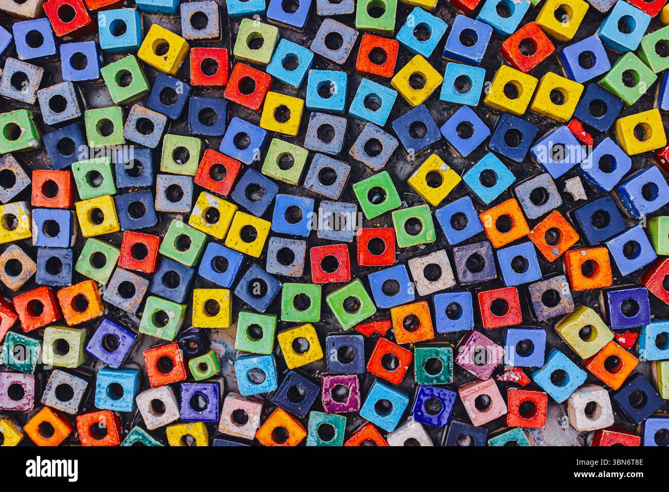 Primo piano del passaggio pubblico pavimentato con colorate perline quadrate, creando un mosaico astratto che mostra la diversità e il design urbano. Foto Stock