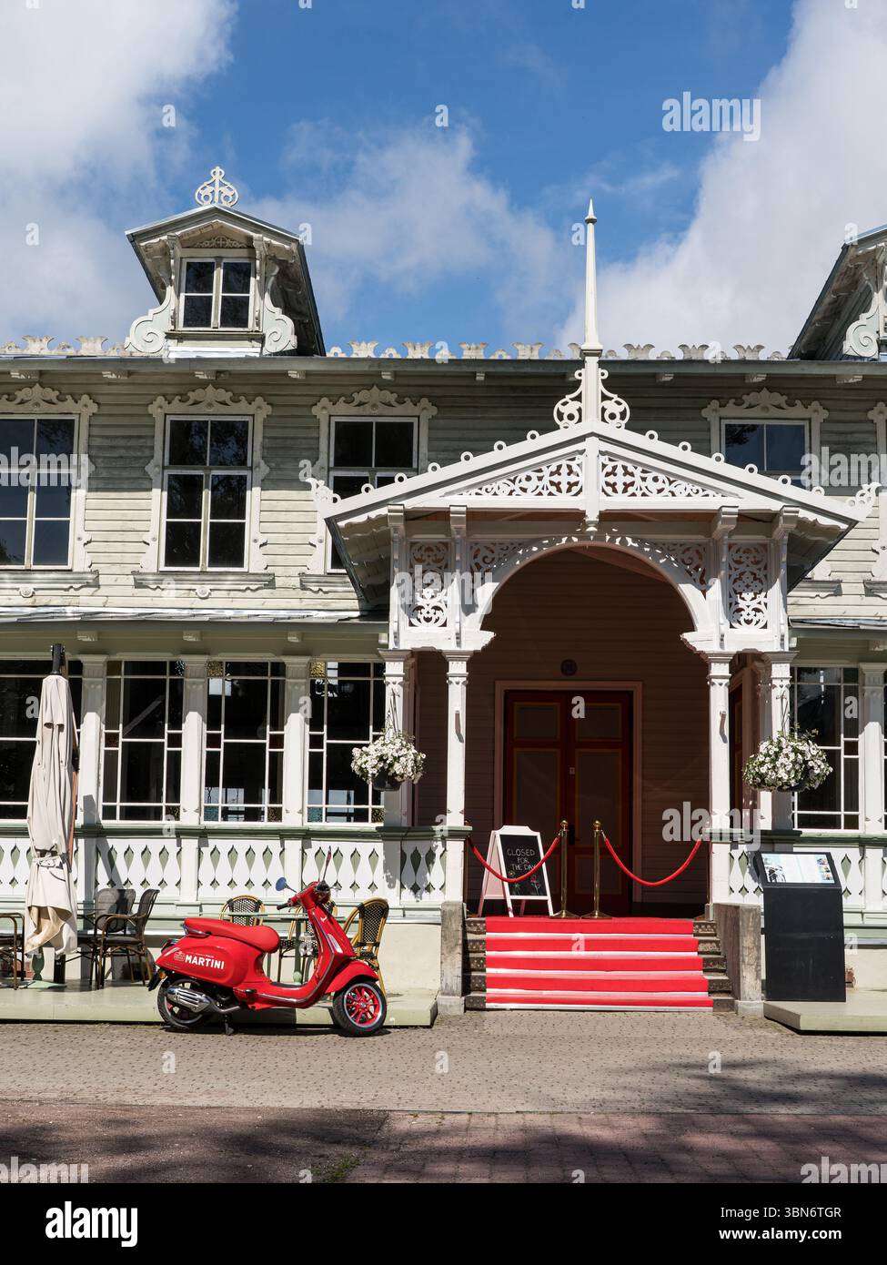 Storico Haapsalu Kuursaal in legno con scooter rosso parcheggiato di fronte, Estonia. Foto Stock