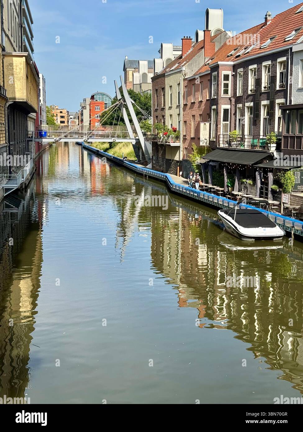 Vista sul canale con moderna passerella e storiche case lungo il fiume a Gand (Gent), Belgio. - Immagine stock catturata con smartphone