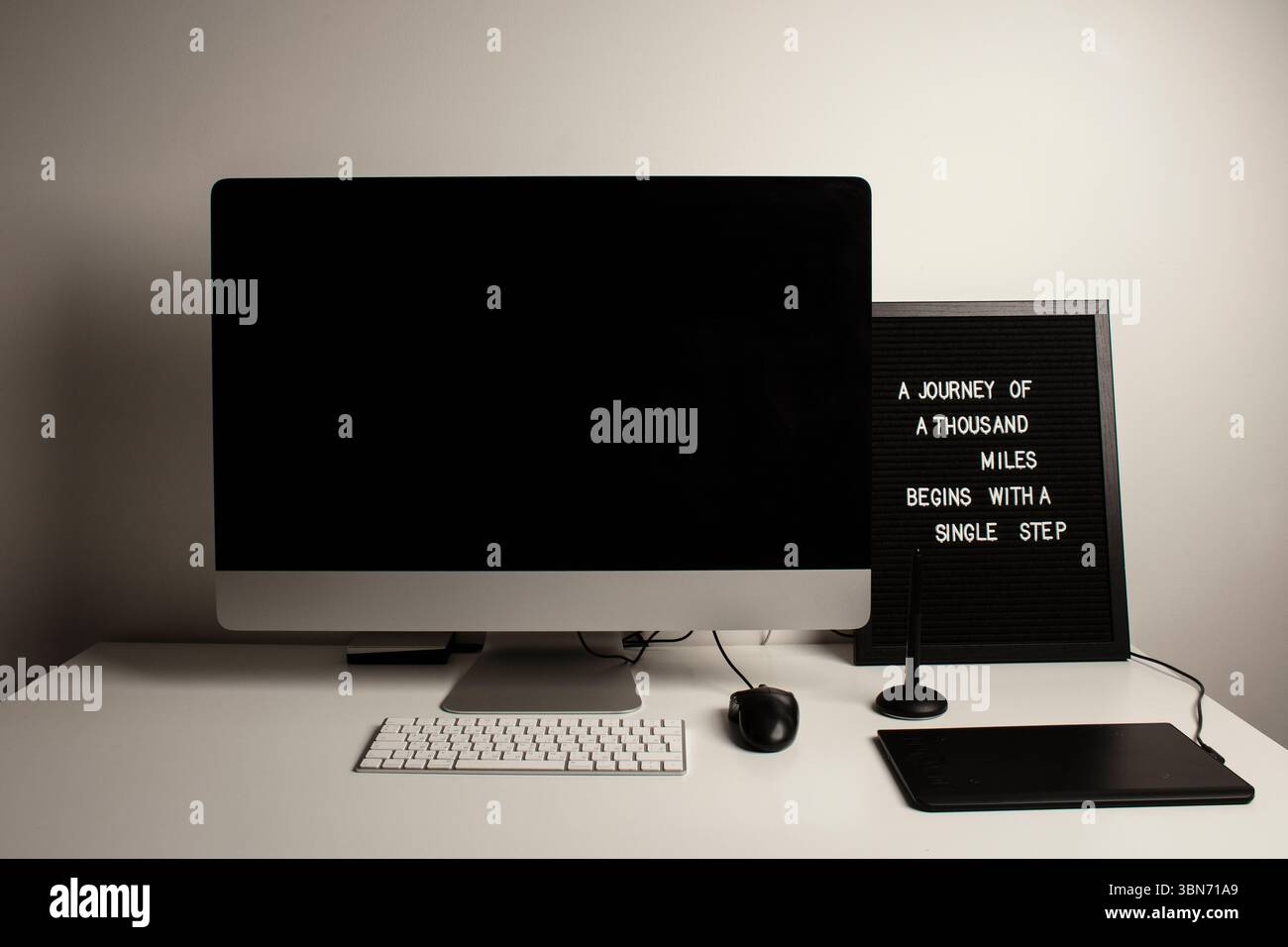 Spazio di lavoro minimalista per l'ufficio domestico con un computer desktop, una tastiera, un notebook, un tablet con penna su una scrivania bianca e pulita. Freelance a casa. Arte a casa. Foto Stock