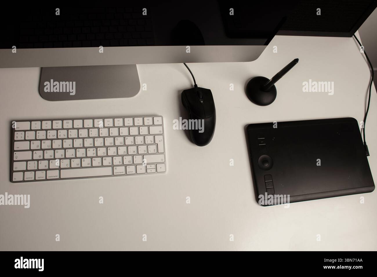 Spazio di lavoro minimalista per l'ufficio domestico con un computer desktop, una tastiera, un notebook, un tablet con penna su una scrivania bianca e pulita. Freelance a casa. Arte a casa. Foto Stock