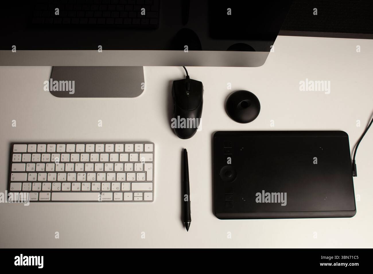 Spazio di lavoro minimalista per l'ufficio domestico con un computer desktop, una tastiera, un notebook, un tablet con penna su una scrivania bianca e pulita. Freelance a casa. Arte a casa. Foto Stock