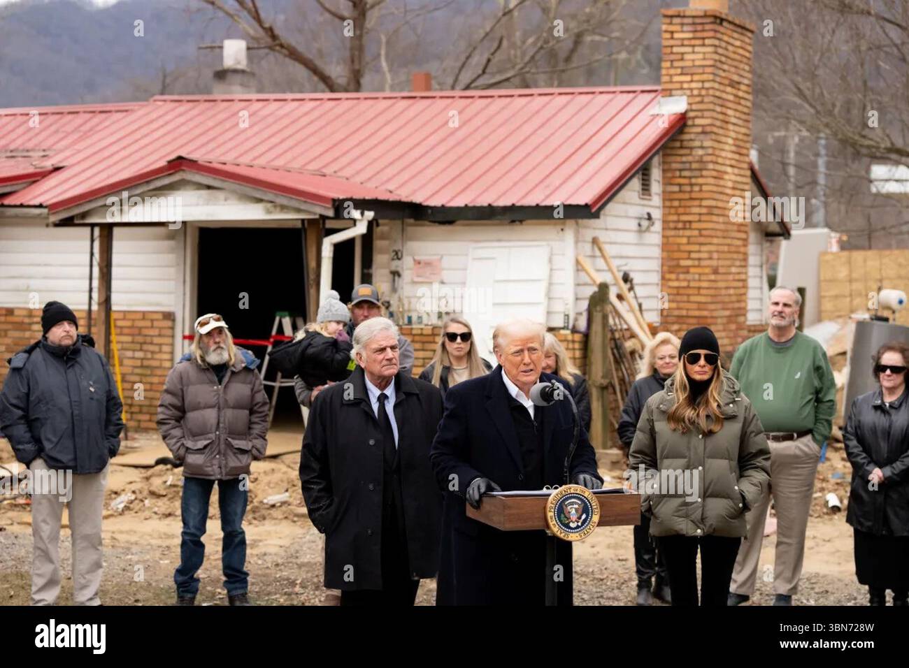 Il presidente Donald Trump parla vicino a una casa danneggiata dall'uragano Helene, affiancato dalla First Lady Melania Trump e dai residenti locali, insieme a Franklin Graham e ai soccorritori di emergenza dopo l'uragano Helene in una stazione di pubblica sicurezza a Swannanoa, Carolina del Nord, 24 gennaio 2025. Immagine per gentile concessione della Casa Bianca. Foto Stock