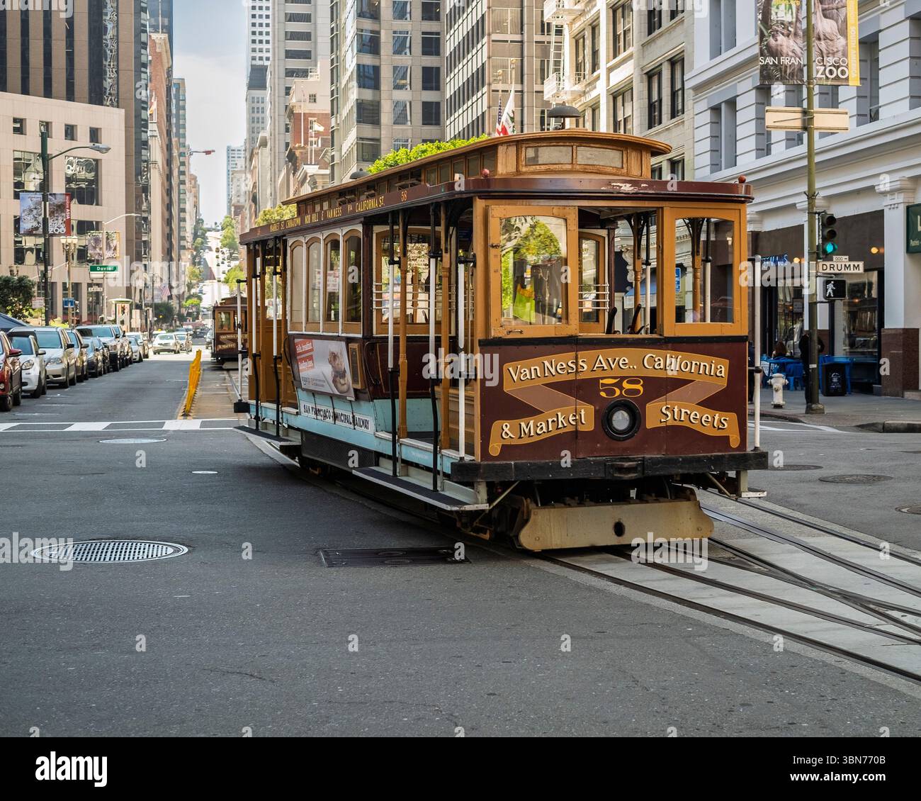 Una storica funivia viaggia lungo Van Ness Avenue, vicino all'incrocio con California Street e Market Street, mostrando l'iconica trenino della città Foto Stock
