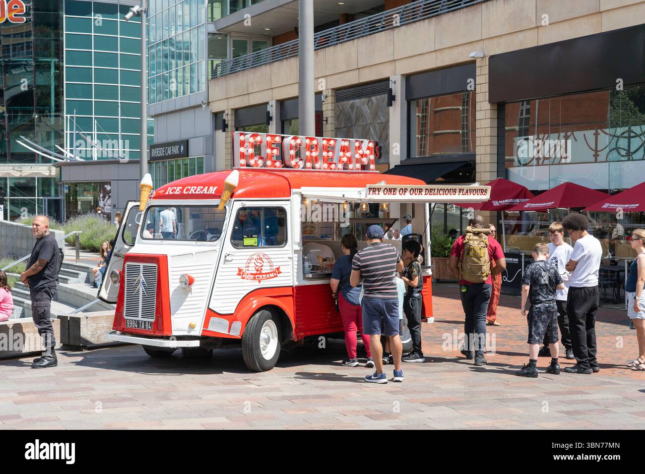 Durante una calda giornata estiva sull'Oracle Riverside, vicino al fiume Kennet, gli ospiti fanno la fila per un gelato pluripremiato da un furgone del gelato. Reading, Regno Unito Foto Stock