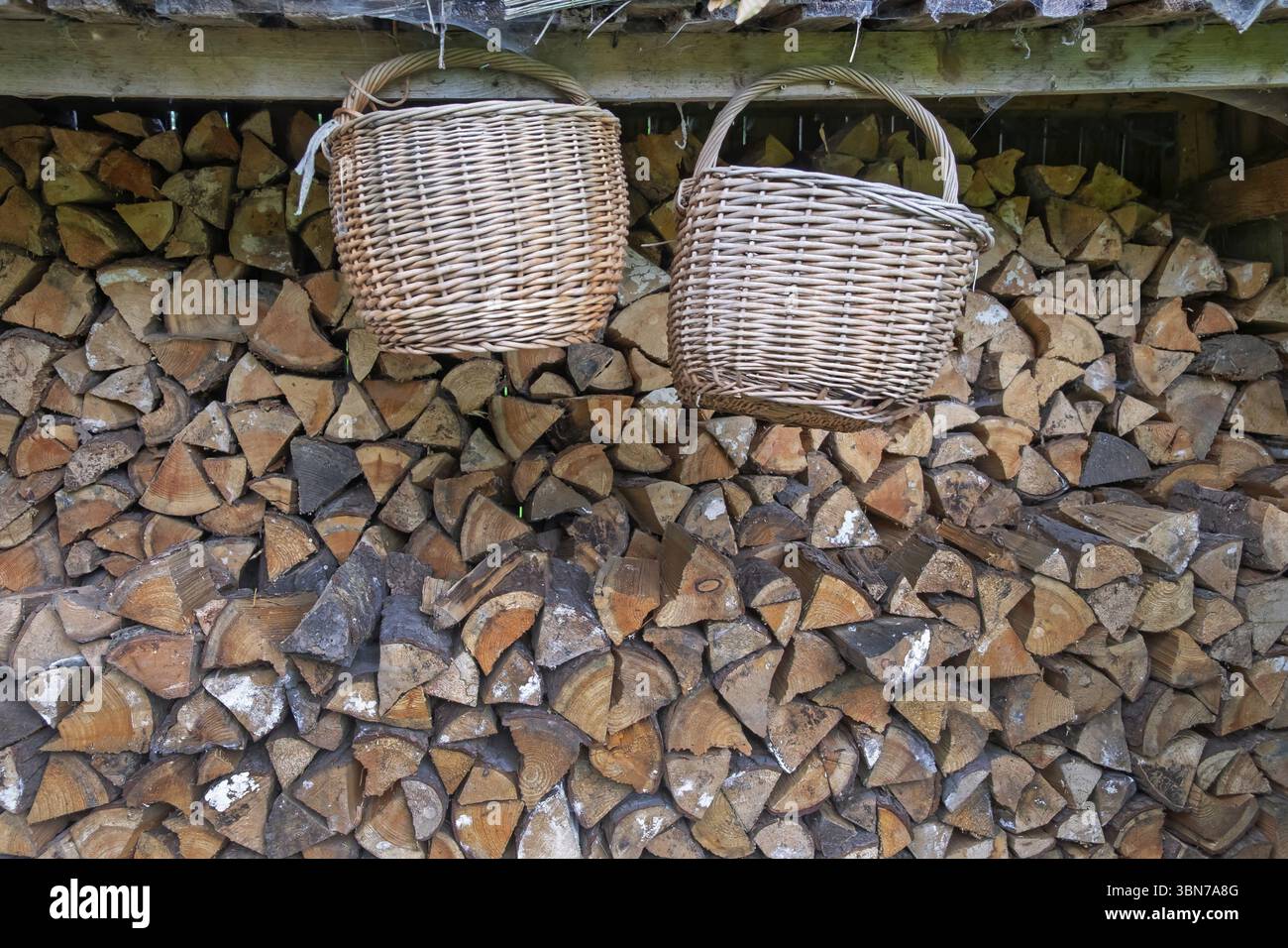 Due cesti appesi davanti a un mucchio di legno, Germania, Europa Foto Stock