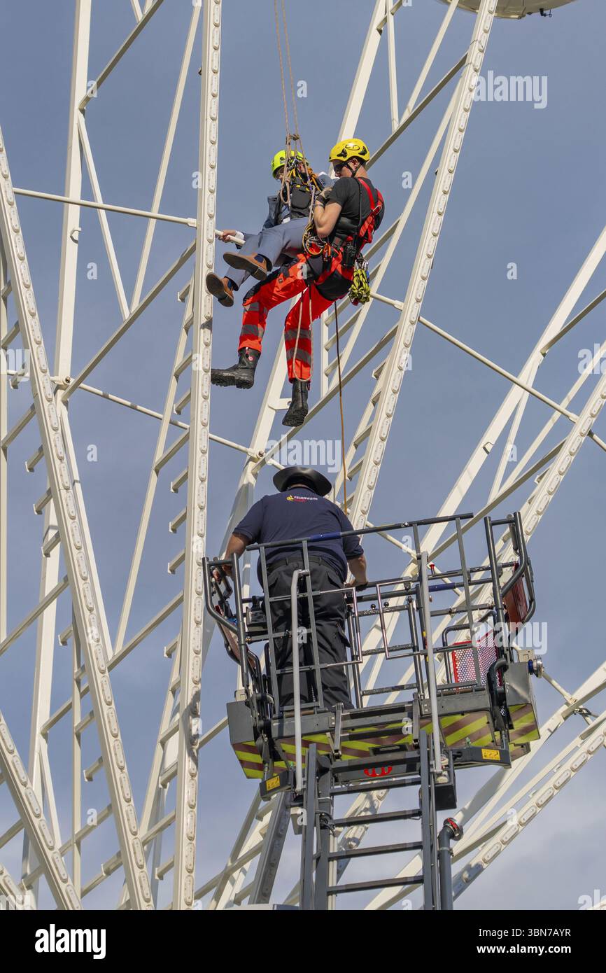 Vigili del fuoco in missione di salvataggio su una ruota panoramica con supporto gru, esercitazione dei vigili del fuoco per il salvataggio in gondola, Germania, Europa Foto Stock