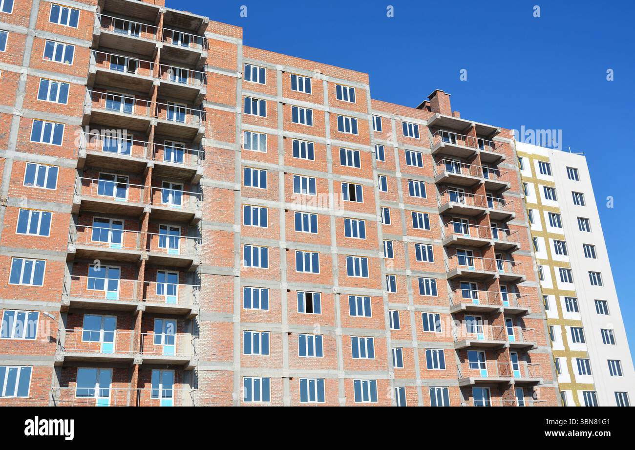 Edifici residenziali multifamiliari in costruzione. Gli edifici residenziali multi-famiglia sono strutture progettate per ospitare più soggiorni separati Foto Stock