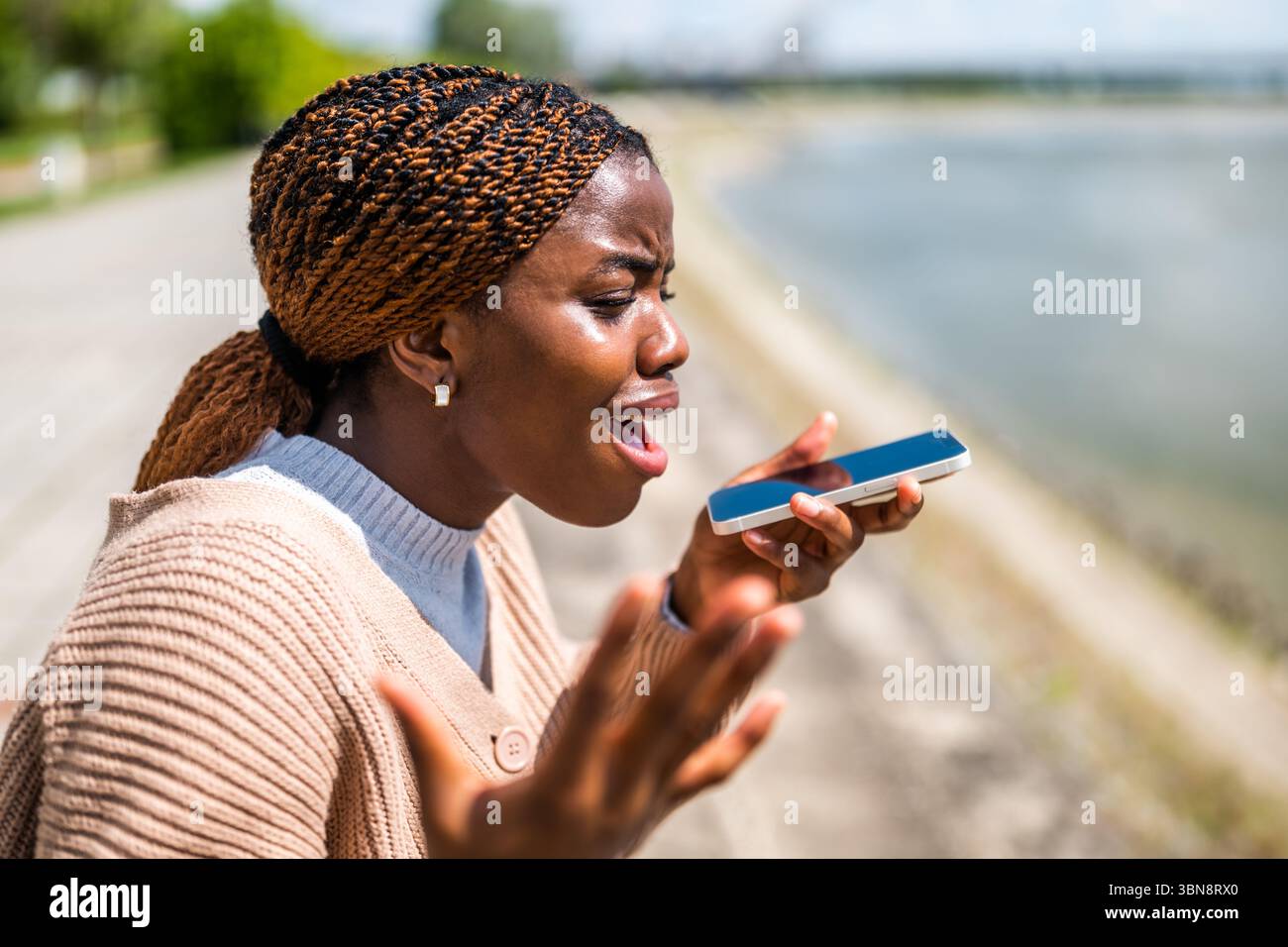 La giovane donna nera sta parlando al telefono. Lei è ansiosa e preoccupata. Foto Stock