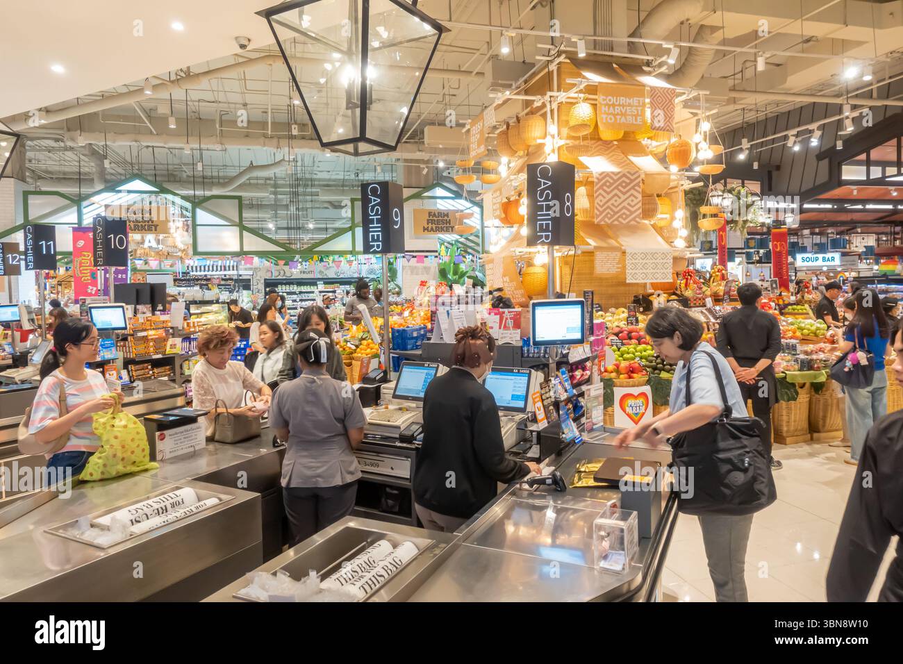 Cassieri al bancone che serve i clienti, Gourmet Market, Siam Paragon, Pathum Wan, Bangkok, Thailandia Foto Stock
