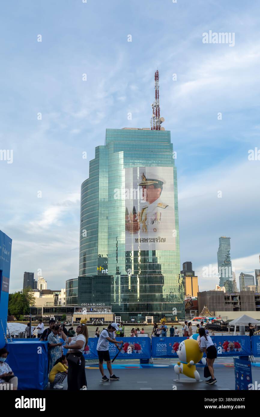 Immagine gigante del re tailandese su una facciata di vetro di un edificio moderno sul lato del fiume Chao Phraya a Bangkok, vista dall'ambiente esterno di Iconsiam Foto Stock