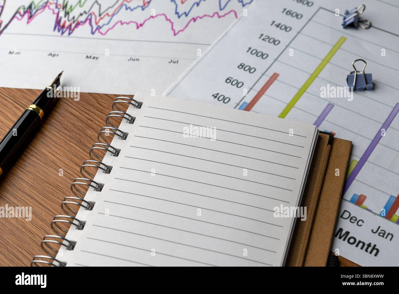 Grafici e grafici finanziari con quaderno sul tavolo. Analisi aziendale, pianificazione finanziaria, report sullo stato, concetto di interpretazione dei dati. Foto Stock