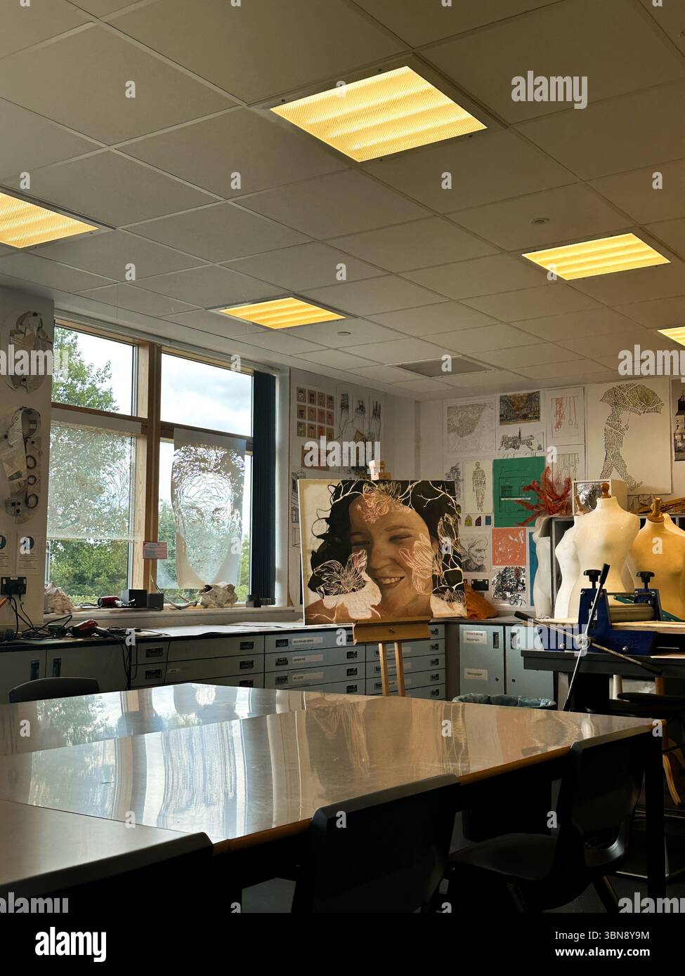 Aula d'arte con macchine da cucire e opere d'arte per studenti. - Immagine stock catturata con smartphone