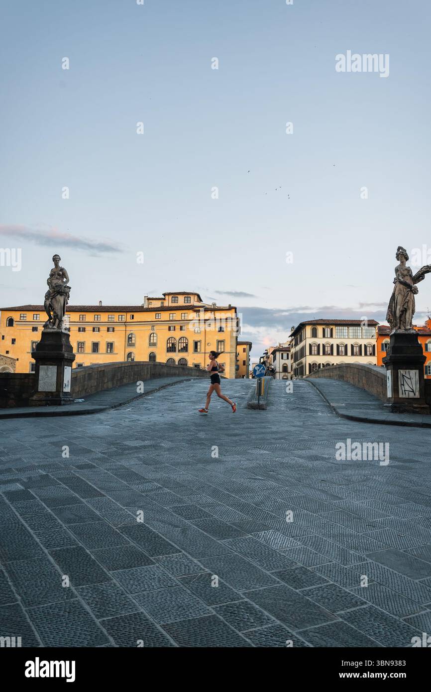 Mattina d'estate a Firenze. Ponto Vecchio e il centro storico. La gente fa jogging all'alba e non ci sono turisti. Foto Stock