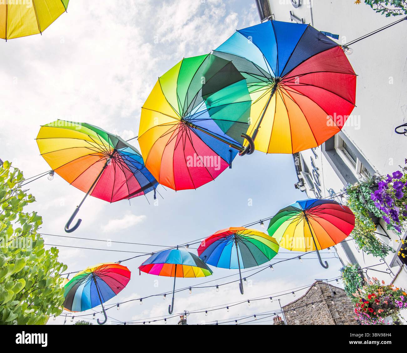 Ombrelli colorati, accattivanti, sospesi e color arcobaleno al Black Horse Hotel di Garrs Lane, Grassington. Yorkshire Dales National Park. Foto Stock