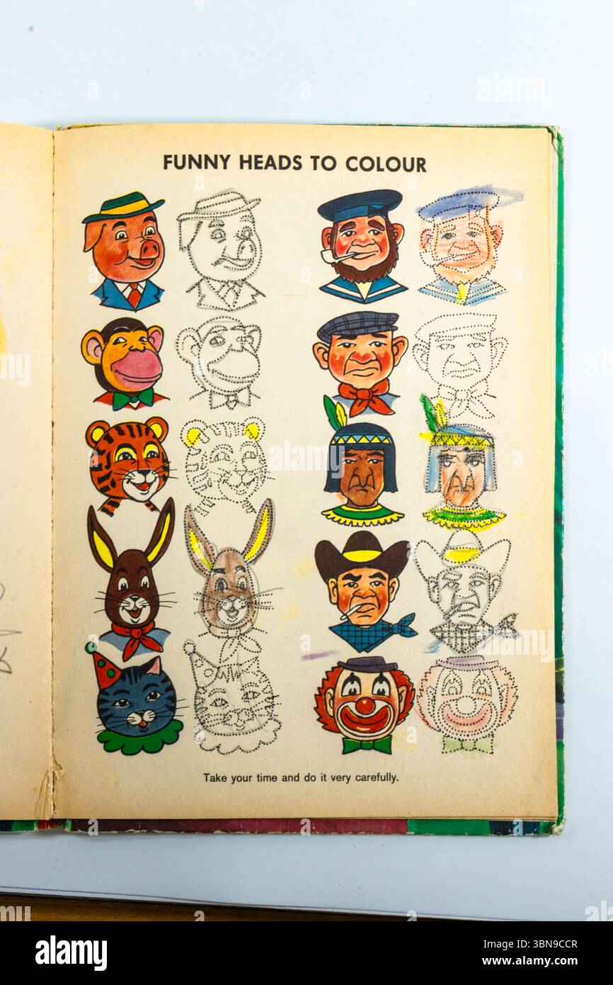 Una pagina di libri da colorare vintage intitolata "Funny Heads to Colour" con vari volti illustrati e disegnati di cartoni animati. Foto Stock