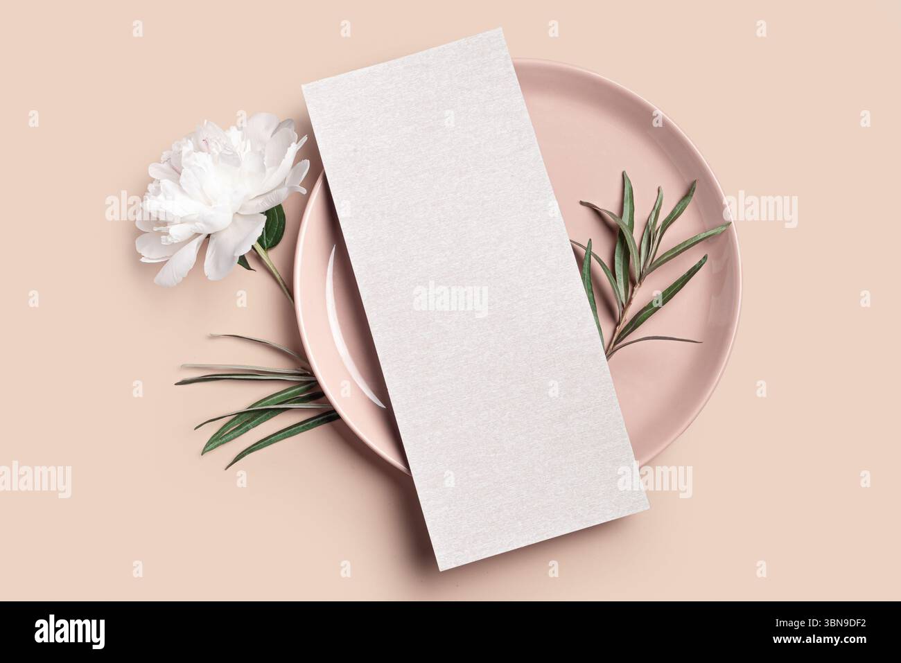 Carta menu 4x9 vuota con piatto, fiore di peonia e foglie di eucalipto su sfondo beige neutro. Mockup con carta d'invito per matrimoni dal design minimal ed elegante con fl Foto Stock