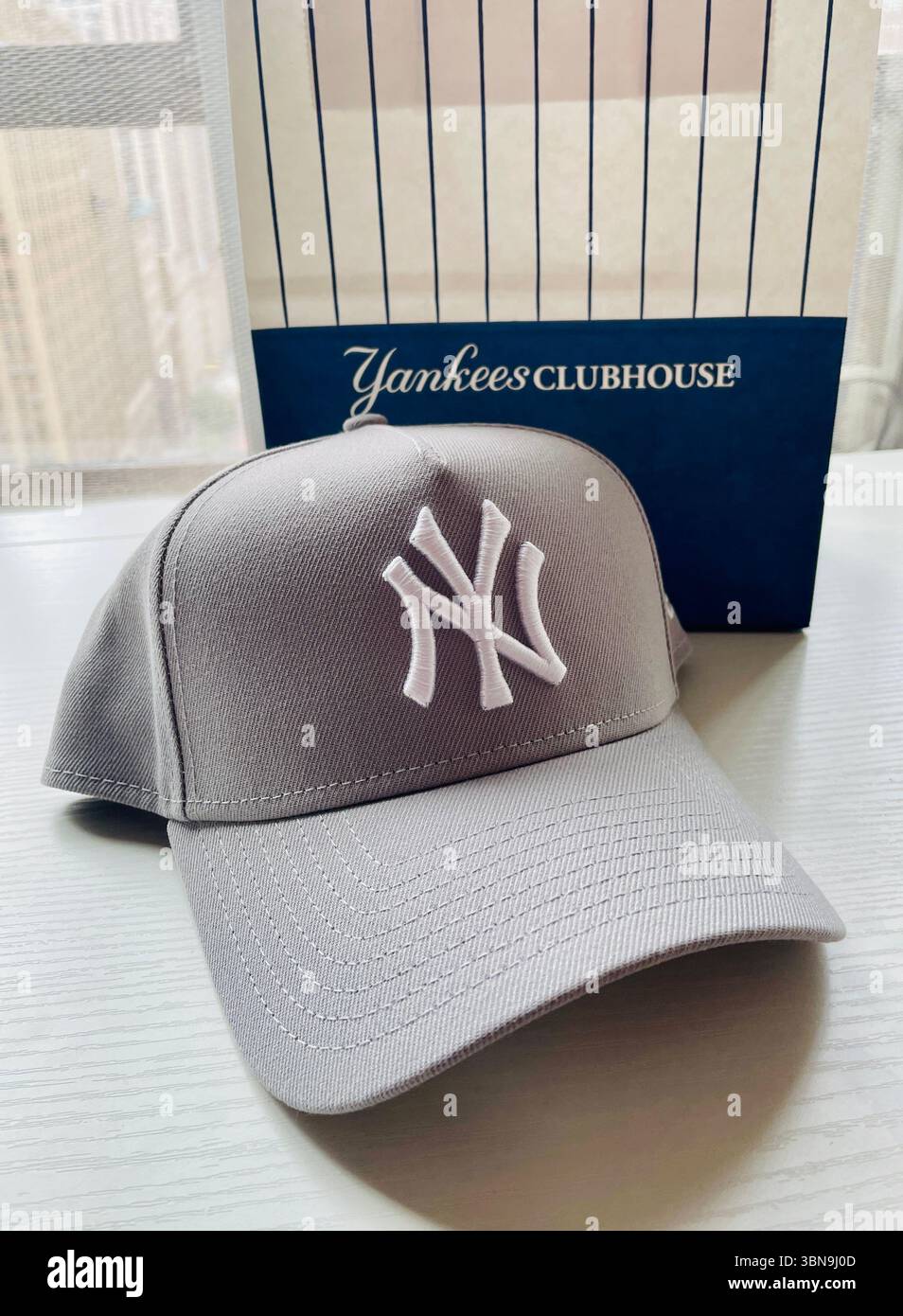 Primo piano di un cappellino da baseball con licenza ufficiale dei New York Yankees dal negozio Yankees Clubhouse sulla Fifth Avenue, 2025, New York City, USA - Immagine stock catturata con smartphone