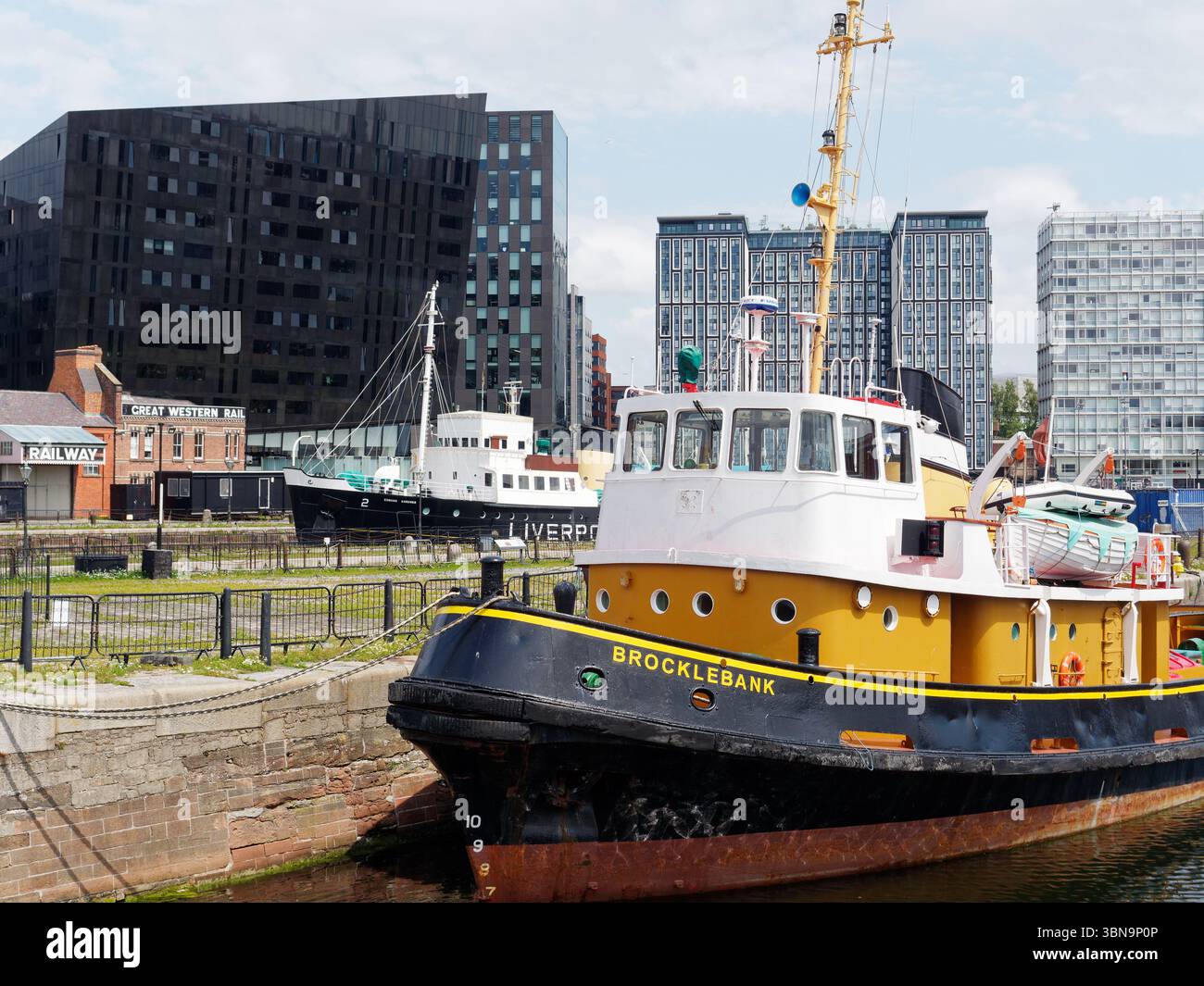 Navi/navi in un cantiere navale/attracco con edifici moderni alle spalle nella città di Liverpool, Merseyside, Inghilterra. 30 giugno 2025 Foto Stock