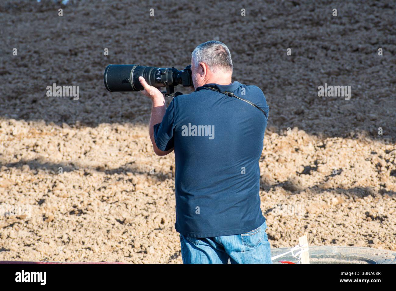 28 giugno 2025 – Nephi, Utah: Un fotografo scatta foto di piloti di motocross dal bordo dell'arena sterrata durante l'evento Juab Xtreme Racing. Foto Stock