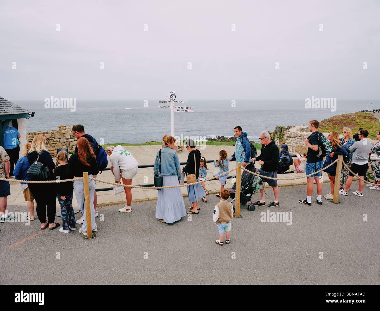 La coda per il famoso cartello Lands End Fotografia a Lands End Cornovaglia Inghilterra Regno Unito - turismo turisti clima nuvoloso Foto Stock