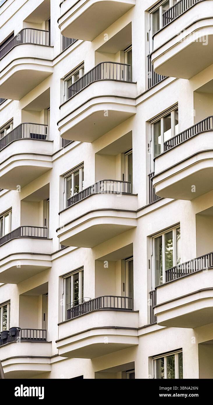 Moderno edificio residenziale con balconi curvi e facciata bianca a Berlino, Germania - linee architettoniche pulite e design contemporaneo. Foto Stock