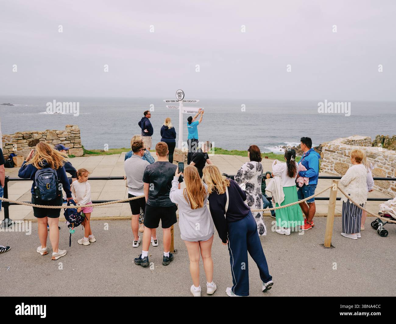 La coda per il famoso cartello Lands End Fotografia a Lands End Cornovaglia Inghilterra Regno Unito - turismo turisti clima nuvoloso Foto Stock