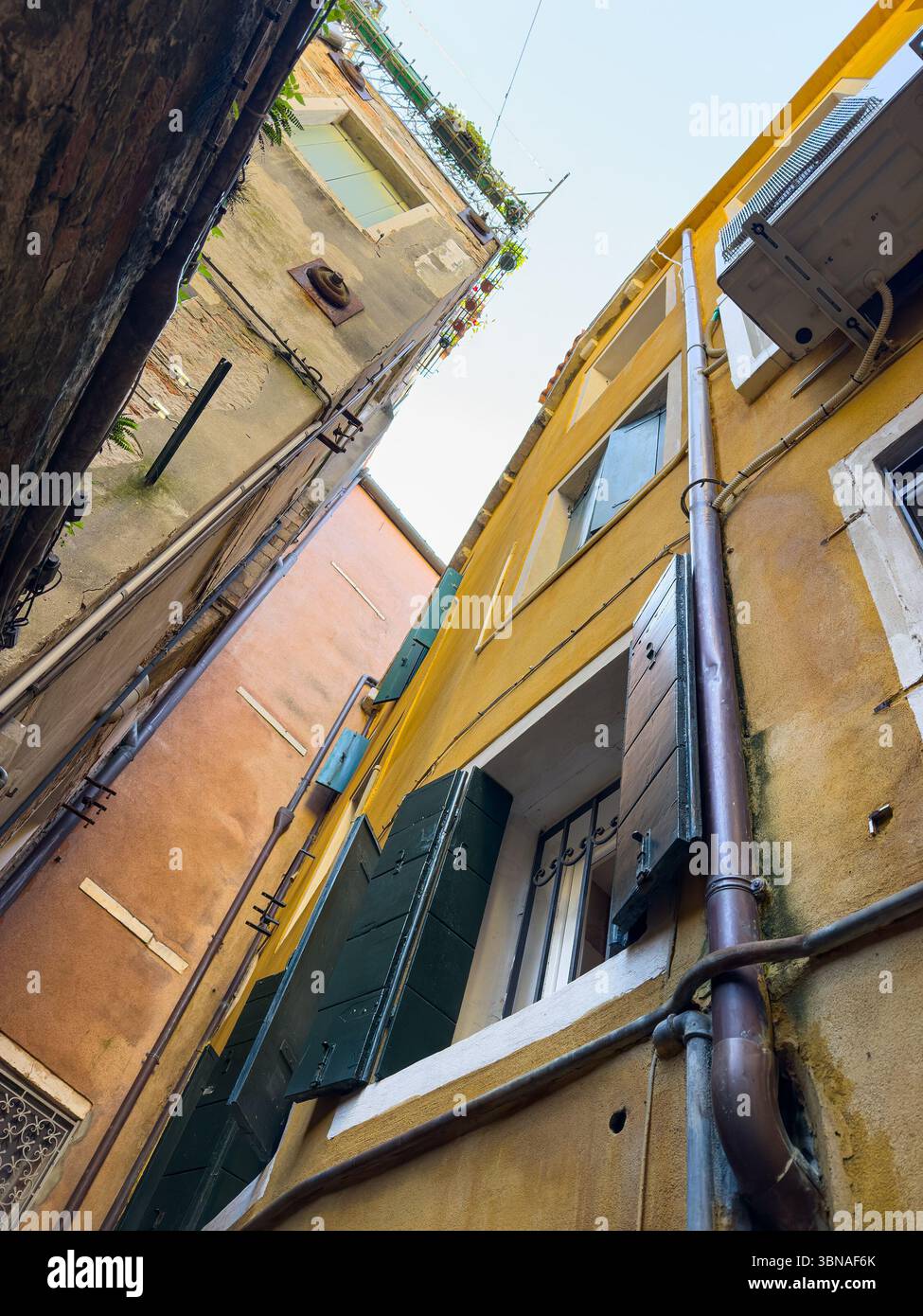 Vista dal basso verso l'alto delle strette stradine di Venezia in Italia. Vista claustrofobica Foto Stock