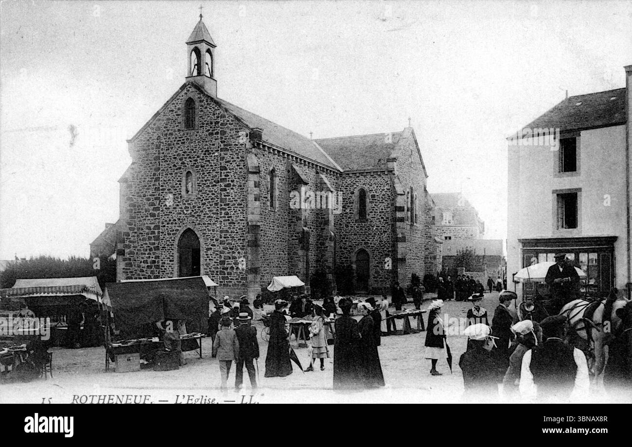 Una vivace piazza del villaggio di Rothéneuf è incentrata su una chiesa in pietra con un campanile e finestre ad arco. La gente del posto in abiti d'epoca si riunisce intorno alle bancarelle del mercato e ai carri, evocando una vivace scena dei primi anni del XX secolo. L'architettura è modesta, intemprata e distintamente bretone. Pubblicato negli anni '1910 da Léon & Lévy di Parigi. Da una cartolina originale. Foto Stock