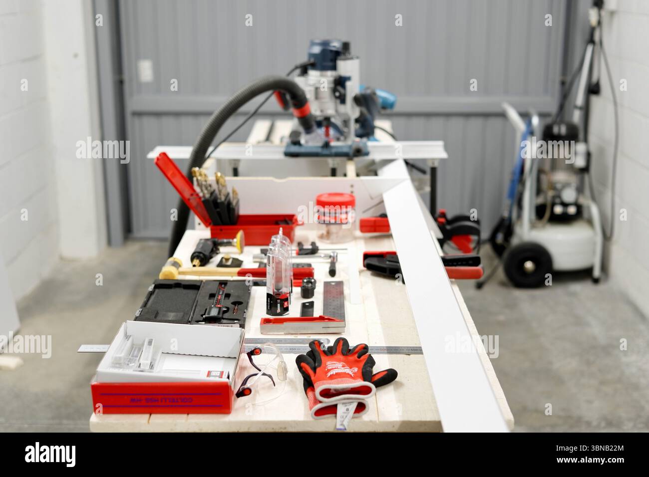 Una precisa configurazione del router per la lavorazione del legno con utensili elettrici su un banco da lavoro all'interno di Modena, Emilia-Romagna, Italia. Foto Stock