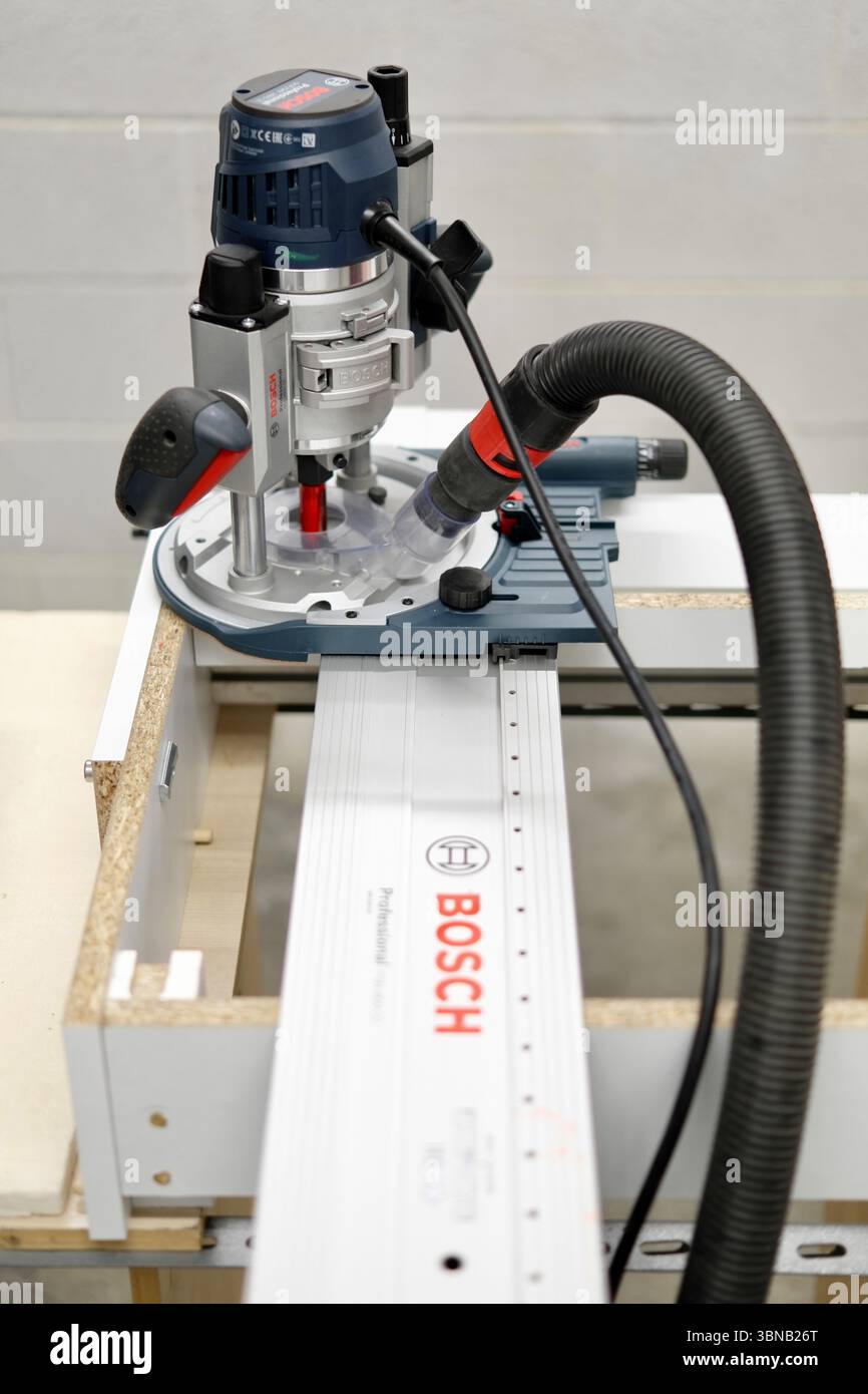 Una precisa configurazione del router per la lavorazione del legno con utensili elettrici su un banco da lavoro all'interno di Modena, Emilia-Romagna, Italia. Foto Stock