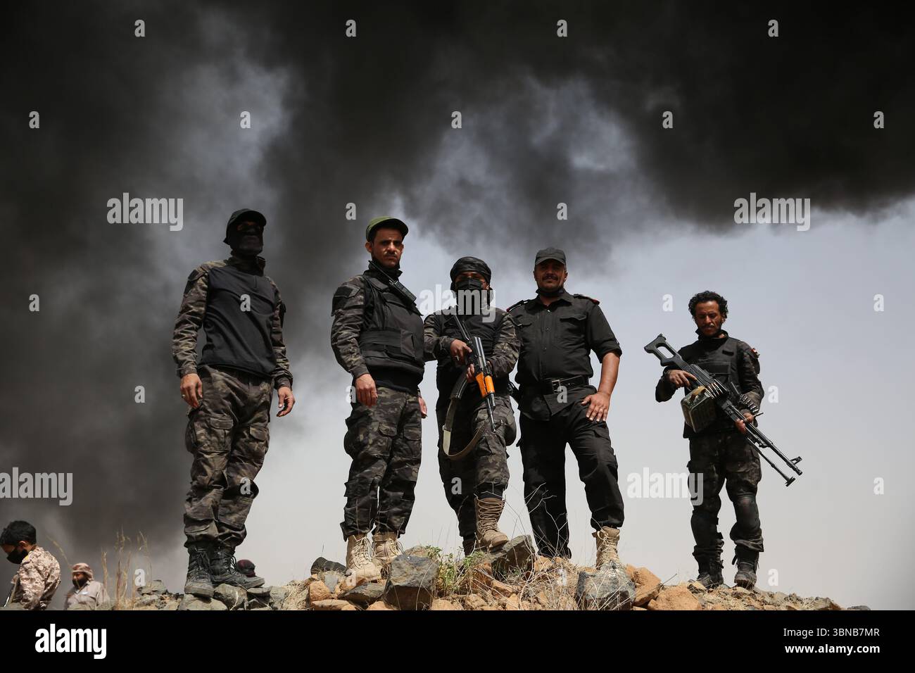 Un soldato sta di guardia vicino a una pila di droghe confiscate mentre bruciano, a Sana'a, Yemen, 1 luglio 2025. Ameen Ali Foto Stock