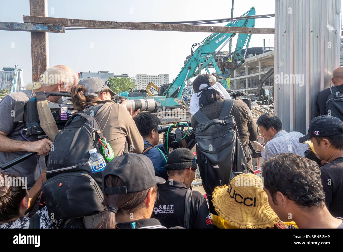 Folla di cameraman e fotografi dietro le barricate, osservando un escavatore nel sito dei danni causati dal terremoto a Chatuchak, Bangkok, Thailandia Foto Stock