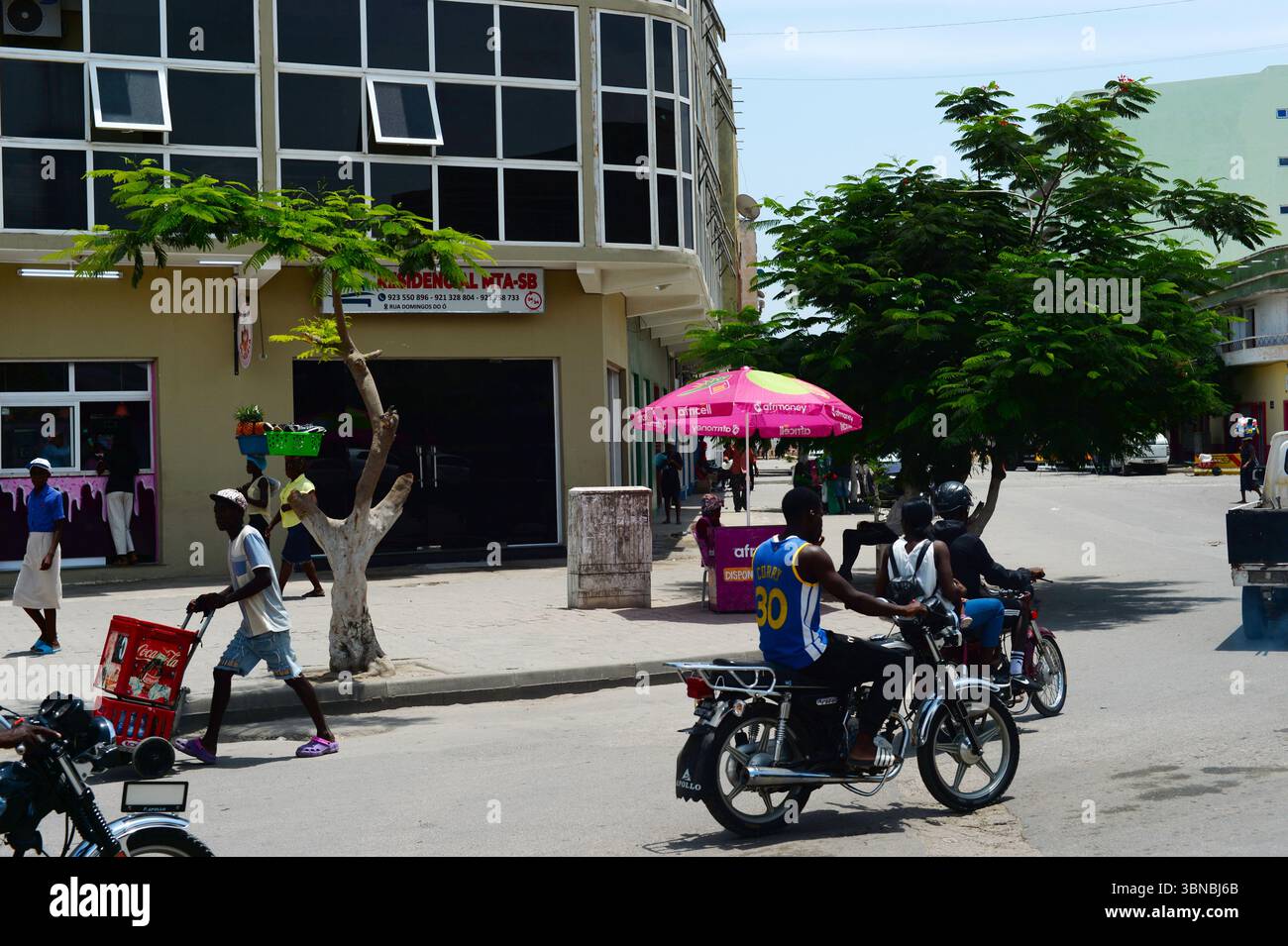BENGUELA, ANGOLA - 13 febbraio 2025: Persone che camminano per la strada di Benguela. Tipica scena di strada Foto Stock