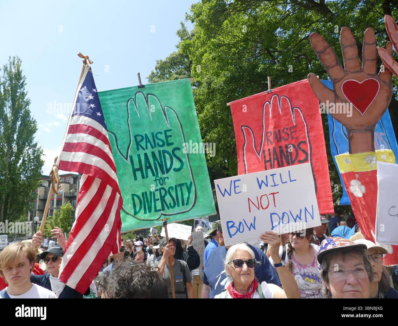SEATTLE - 14 giugno 2025 - No Kings Rally - manifestanti multietnici che raccolgono, tengono cartelli e bandiere a sostegno della giustizia sociale al Cal Anderson Park civ Foto Stock