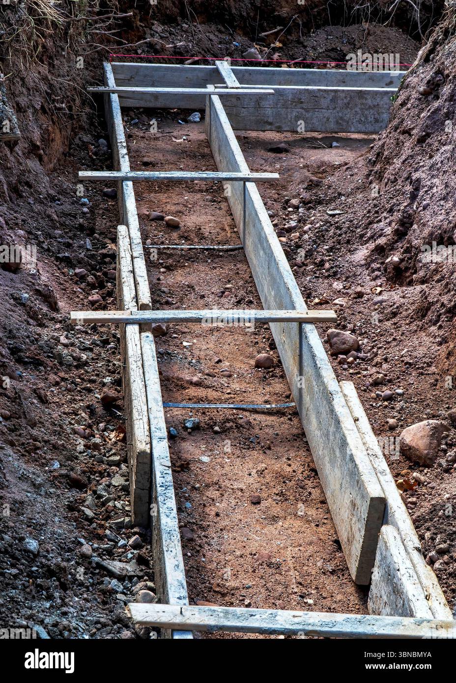 Costruzione di fondazioni. Forme in legno pronte per il versamento del primo strato di cemento. Foto Stock