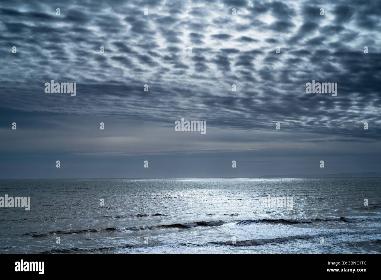 Spettacolare cielo chiazzato e chiaro di luna sull'acqua in una tranquilla scena marina a Barton on Sea sulla costa meridionale dell'Inghilterra, Regno Unito Foto Stock