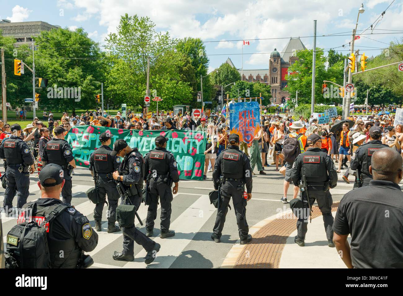 Toronto, Canada, 1° luglio 2025. La polizia affronta i manifestanti indigeni e i sostenitori vicino alla legislatura dell'Ontario in occasione del Canada Day. I manifestanti hanno denunciato la legislazione che dicono permetterà l'estrazione di risorse che viola la loro sovranità e minaccia la loro terra. Colin N. Perkel/Alamy Live News Foto Stock